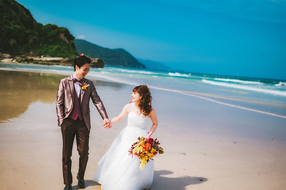 静岡フォトウエディングのフィーノスタイルで撮影した画像集2022年7月17日更新のホテル伊豆急の前の白浜海岸で歩く新郎新婦